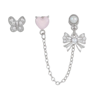 Détail de la puce d'oreille cœur rose et boucles d'oreilles nœud papillon argenté