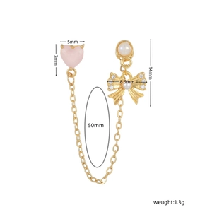 Vue détaillée de la chaîne de boucles d'oreilles cœur rose avec nœud et perle