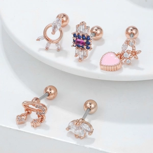 Rose gold heart and zircon cartilage earrings with screw-back design on white display