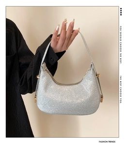 Detail showing shiny silver sequin crescent bag with gold metal hardware and textured finish