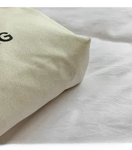 Close-up of premium off-white canvas fabric texture with bold black letter printing