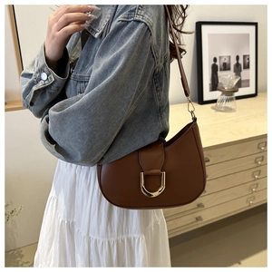 Borsa a mezzaluna in pelle marrone con fibbia a D dorata abbinata a denim e gonna