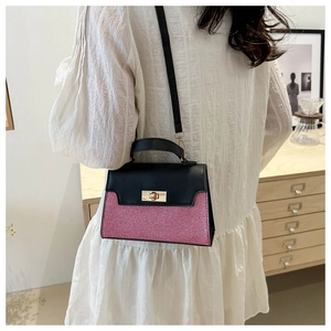 Detail of contrast-color mini handbag with pink glitter finish and golden twist lock