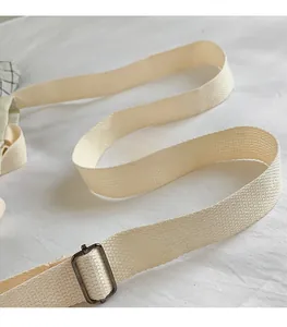 Detail of adjustable off-white canvas shoulder strap with dark grey metal buckle