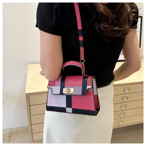 Detail view of colorful plaid crossbody bag with gold twist lock and adjustable strap