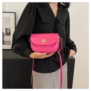 Détail du sac à bandoulière en cuir rose vif avec fermoir géométrique doré chic