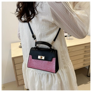 Detail of pink sequin patchwork on black leather crossbody bag with metal lock