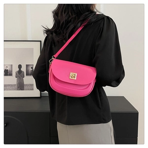 Détail d'un sac à main fuchsia porté par un mannequin dans un intérieur chic et moderne