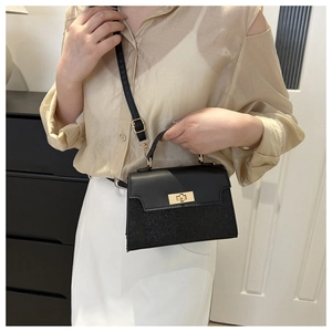 Chic black contrast handbag with matte leather and sequin finish, shown on model