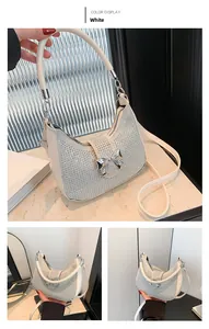 Macro detail of white shoulder bag with silver rhinestones and metal bow accent