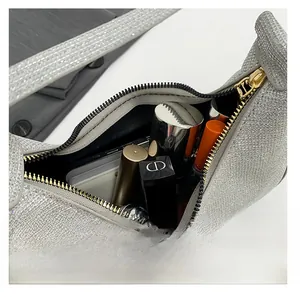 Interior capacity of the silver sequin crescent bag showing lipsticks and phone