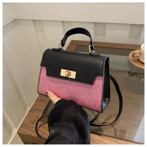 Close-up of contrast square handbag with pink glitter texture and gold twist lock