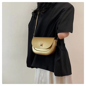 Détail d'un sac besace métallisé avec boucle carrée dorée et fine bandoulière en cuir