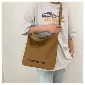 Brown canvas tote bag with adjustable shoulder strap and print for casual daily use