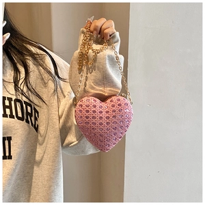 Close-up of pink rhinestone heart-shaped mini bag with gold chain strap for parties