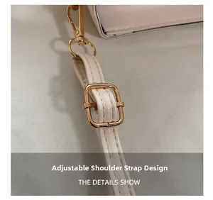 Detail of adjustable beige leather shoulder strap with gold-tone metal buckles and hooks