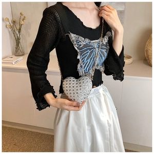 Detail of silver heart-shaped crossbody bag with rhinestones and gold chain strap