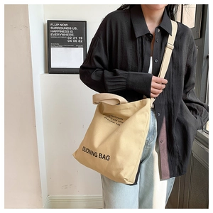 Street style view of large canvas tote bag showing the handles and dual strap design