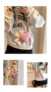Detailed view of pink heart-shaped bag featuring shimmering sequins and a gold chain strap