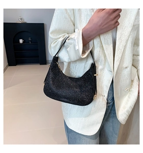 Close-up of black sequin hobo bag with gold hardware worn as a chic underarm purse
