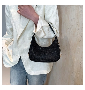 Close-up of sparkling black rhinestone hobo bag with gold hardware detail