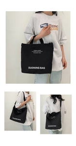Detail of black canvas tote bag showing fashion trends print and shoulder strap use