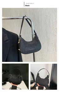 Detail of black sequined crescent hobo bag with shimmering texture and gold hardware