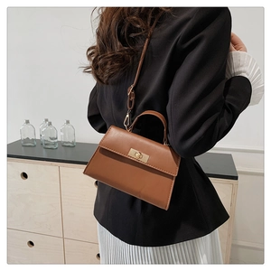 Brown PU leather crossbody bag with gold twist lock shown as a stylish shoulder bag