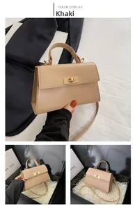 Detail view of khaki faux leather handbag with turn-lock closure and box packaging