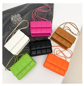 Flat lay of colorful quilted crossbody bags with chain straps in various vibrant colors