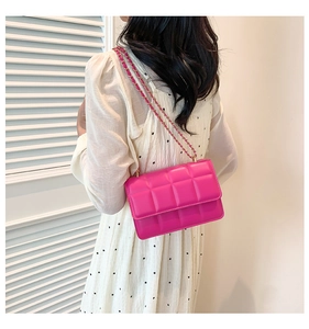 Detail of vibrant pink quilted leather crossbody bag with elegant gold chain strap