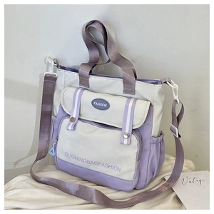 Detail der lila-beigen Nylon-Tasche mit Kontrastfarben und modischem Logo-Aufdruck