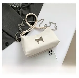 Detailansicht der weißen Schultertasche mit Lederschleife und Größenvergleich