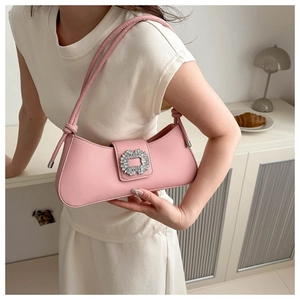 Close-up of pink underarm baguette bag with sparkling rhinestone square buckle and knot strap