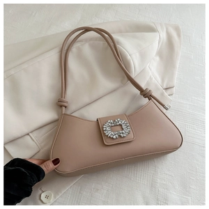 Detail of beige leather shoulder bag with crystal buckle and knotted strap on white blazer