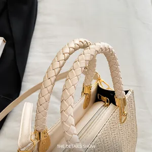 Detail of woven faux leather handle and gold hardware on a summer straw handbag