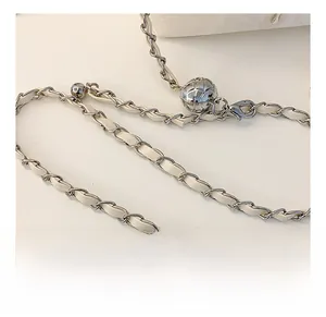 Detail of adjustable silver chain strap with woven cream leather and metal ball slider