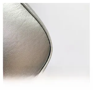 Detail of silver textured leather cross-body bag showing premium stitching and corners