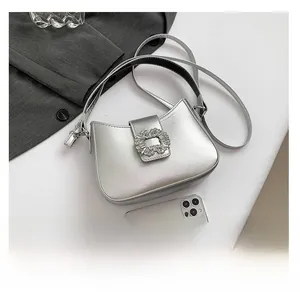 Detail shot of silver metallic crescent bag with rhinestone buckle and slim shoulder strap