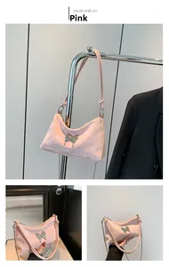 Détail du sac sous le bras en PU rose avec ornement papillon argenté et fermeture éclair
