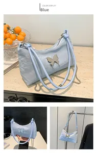 Détail d'un sac à bandoulière en PU bleu clair avec une boucle papillon argentée