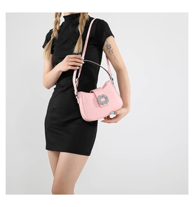Detailed macro view of pink patent leather bag with sparkling rhinestone buckle and slim strap