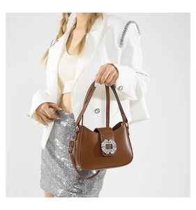 Brown leather underarm bag featuring a large sparkling square rhinestone buckle detail