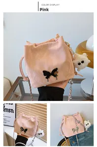 Close-up of pink pleated bucket bag with black metal bow and plush cartoon keychain