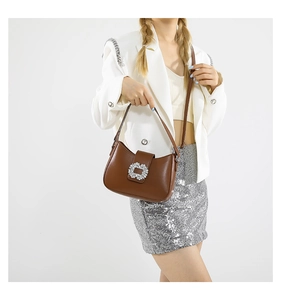 Brown faux leather shoulder bag featuring a large rectangular rhinestone buckle and strap