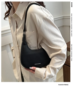 Close-up of black crescent hobo bag with litchi grain leather and fashion text