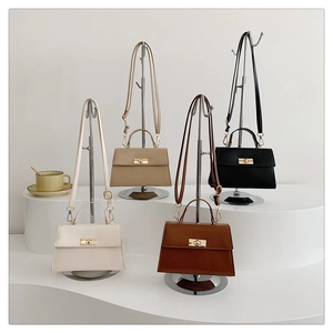 Chic leather crossbody bags in four colors with gold metal locks on a white display stand