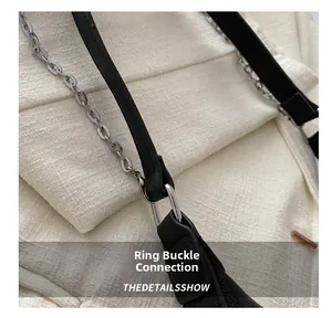 Detailed macro view of silver metal buckle and black leather strap on a shoulder bag