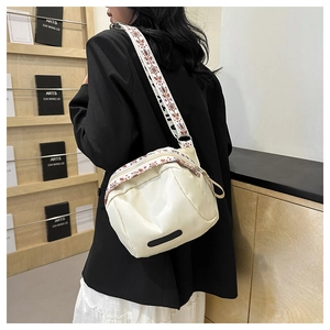 Off-white nylon shell crossbody bag with a wide geometric ethnic print shoulder strap