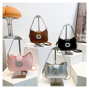 Elegant crescent underarm bag with rhinestone buckle in four colors displayed on stands